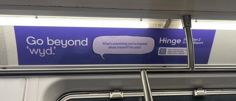 Photo of a subway ad for a dating app, it reads "go beyond wyd?" and then asks
         "what's something your learned about yourself this year?"
