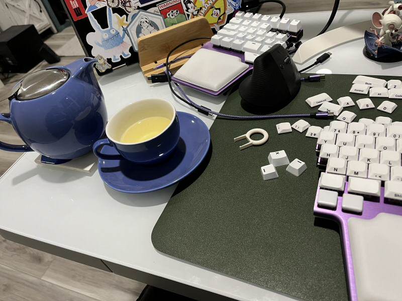 A small teacup and a keyboard and laptop in the background.