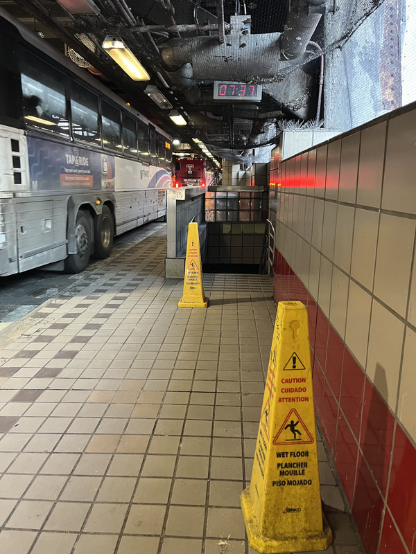 A stair, a cone in front says "Caution, wet floor".