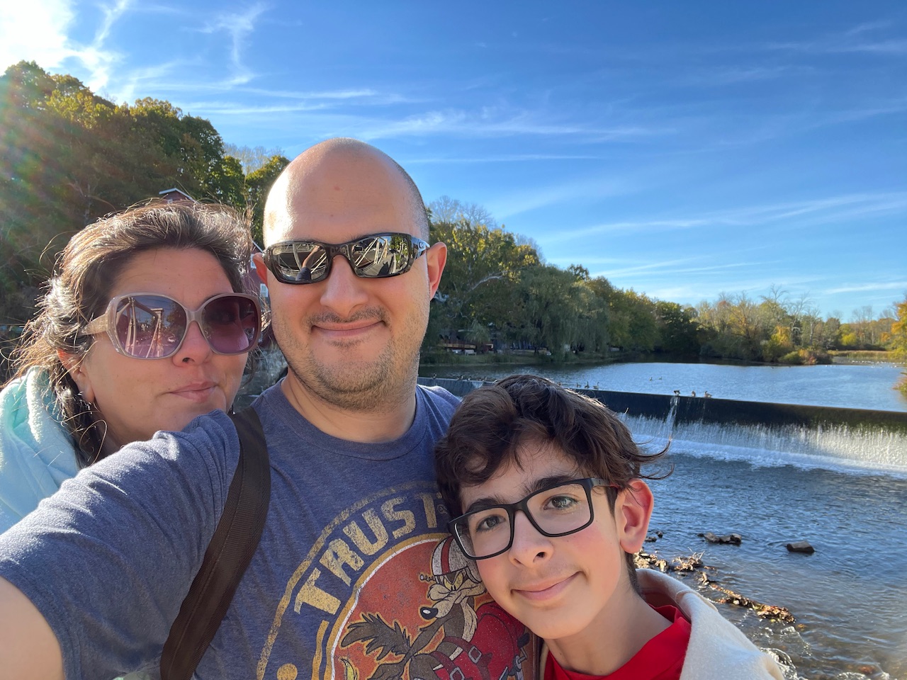 Left to right, a woman, a man, and a preteen, in from of a river.