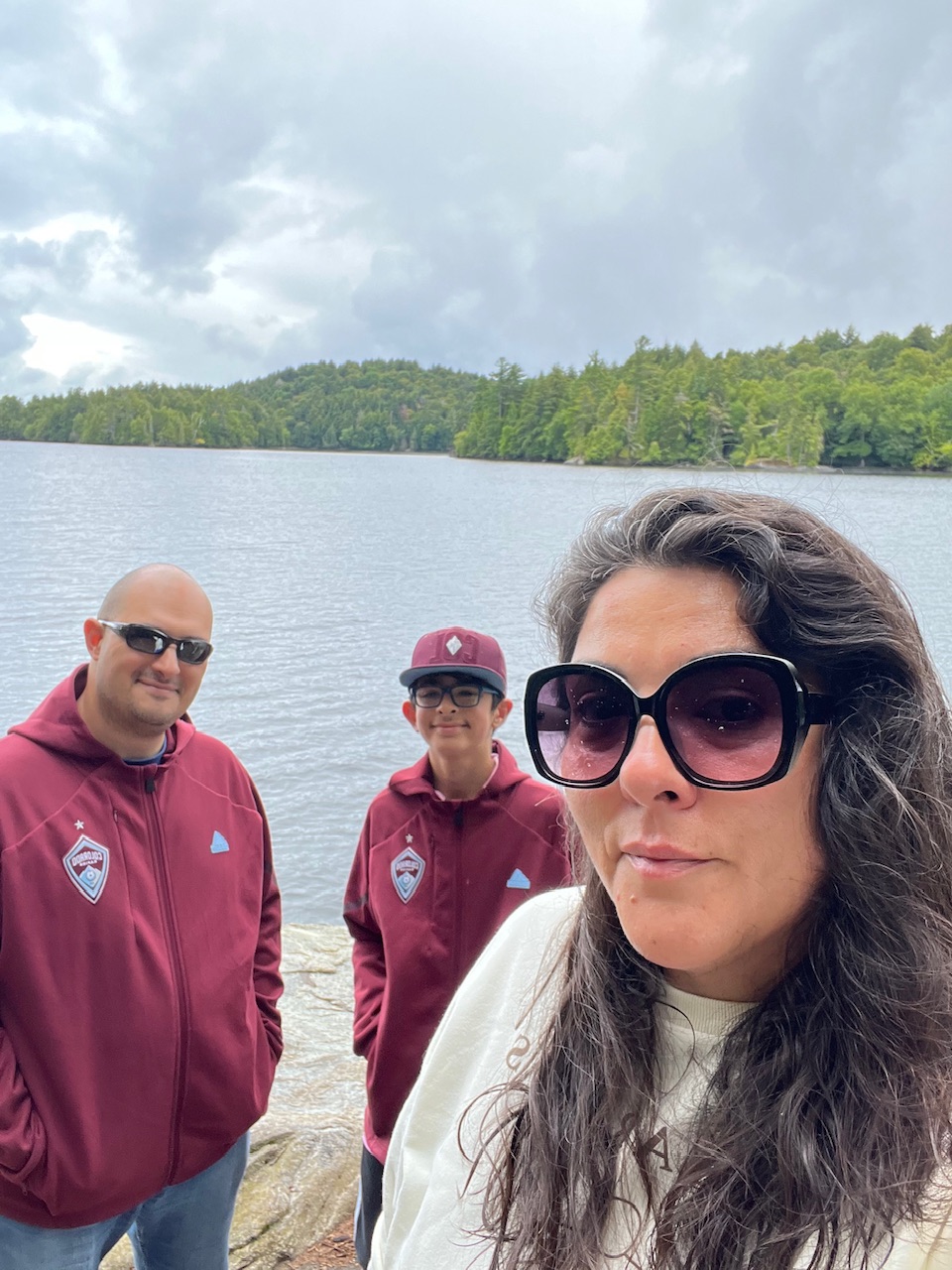 A woman and a kid in a park, surrounded by trees.